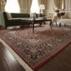 A 4' 8" x 6' 7" Persian Kashan rug styled in a formal sitting area under a mahogany coffee table, showing its scale and deep red tones.