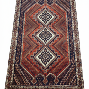 Full view of a 4' 7" x 6' 11" hand-knotted Persian Afshari rug featuring a vertical arrangement of geometric medallions on a deep navy and madder red field.