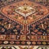Detailed close-up of the diamond medallions on a Shiraz Persian rug, showing the plush wool pile and hand-dyed tribal patterns.