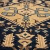 Detailed close-up of the central sky-blue diamond medallion on a Persian Ghafghaz rug, showing the dense hand-knotted wool texture and geometric artistry.