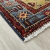 Detail shot of the corner and border of a Tarom Persian rug, showing the multi-layered guard borders and authentic hand-finished fringe.