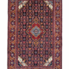 Full view of a 4' 2" x 6' 11" hand-knotted Persian Zanjan rug featuring a rhythmic series of geometric medallions on a vibrant red and deep navy field.