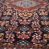Detailed close-up of the geometric medallions on a Zanjan Persian rug, highlighting the lustrous wool and sharp tribal symbols.