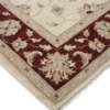 Detailed corner view of an Afghan Chobi rug showing the deep red floral border transition and clean hand-bound edges.