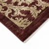 Detailed corner view of a burgundy and cream Afghan Chobi rug showing the clean hand-bound edges and short white fringe.