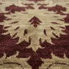 Macro shot showing the dense hand-knotted wool pile and the rich texture of the cream floral patterns on a burgundy Afghan Chobi rug.