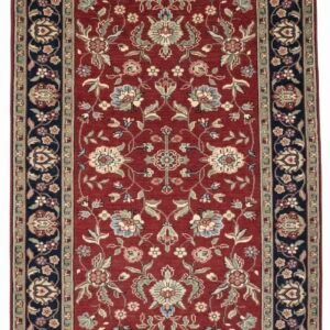 Full overhead view of a rectangular hand-knotted India Mashad wool rug with a deep red field and intricate floral vine patterns and a navy border.