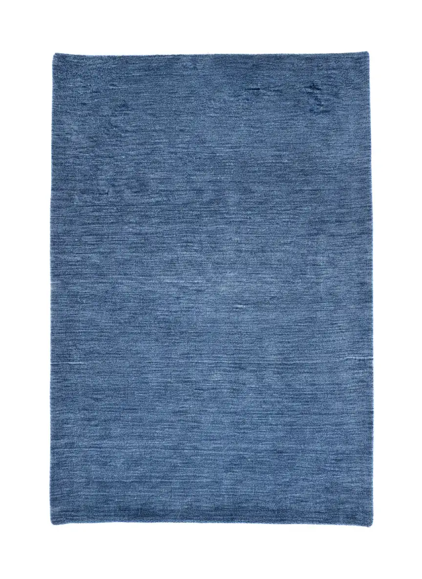 Full overhead view of a rectangular hand-knotted Indian Gabbeh wool rug in a solid denim blue with subtle abrash color variations.