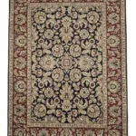 Full overhead view of a rectangular hand-knotted Indian wool rug with a rich red field and dense all-over ivory and blue floral patterns.