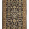 Full overhead view of a rectangular hand-knotted Indian wool rug with a deep navy blue field and repeating large tan floral medallions.