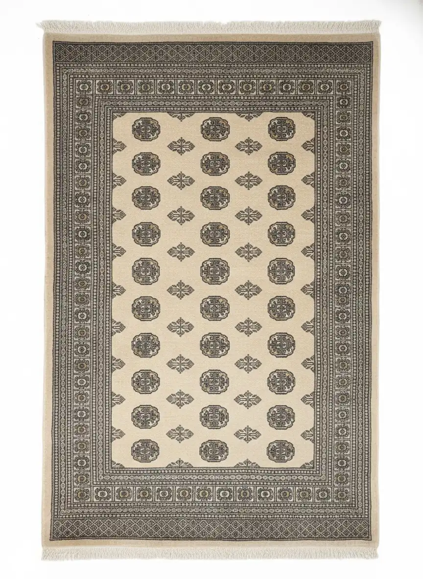 Full overhead view of a rectangular hand-knotted Pakistan Bokhara wool rug with a cream field and repeating charcoal and gold "elephant foot" medallions.