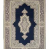 Full overhead view of a rectangular hand-knotted Persian Kerman wool rug with a deep navy blue field and a large ornate ivory and pink central medallion.