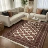 Modern living room with dark wood herringbone floors and a white sectional sofa, featuring a 5'7" X 6'1" ivory and burgundy Turkmen rug under a wooden coffee table.