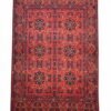Full overhead view of a rectangular hand-knotted Afghan Khal Mohammad wool rug with a deep madder red field and repeating navy geometric medallions.