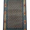Full top-down view of a rectangular hand-knotted Tibet wool rug with a navy blue field and an orange and gold geometric tile pattern.