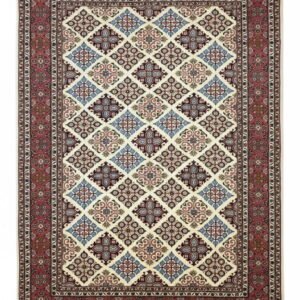 Full overhead view of a rectangular hand-knotted Persian Ilam wool rug with an ivory field and a repeating diagonal diamond pattern in burgundy and blue.