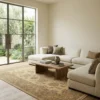 Bright modern living room with a white sectional sofa and light wood floors, featuring a 6' x 8' 8" tan Afghan Chobi rug.