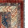 Detailed corner view of a red Afghan wool rug showing the intricate geometric border and hand-bound wool fringe.