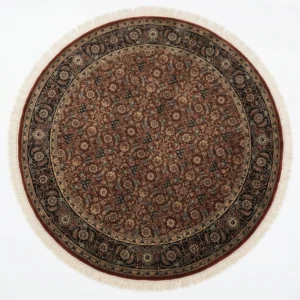 Full overhead view of a 5' x 5' circular hand-knotted Indian wool rug with a rich burgundy field and ornate navy floral borders.