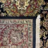 Close-up view of the underside of a hand-knotted Indian wool rug, showing the visible individual knots and authentic textile construction.