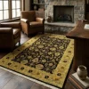 Warmly lit room with a fireplace, leather armchairs, and dark wood floors, featuring a 6' x 8' 8" black and gold Indian wool rug.