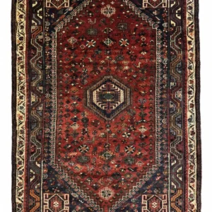 Full overhead view of a rectangular 5' 11" x 8' hand-knotted Persian Qashqai wool rug with a rich red field and three central navy geometric medallions.