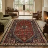 Modern rustic living room with a leather sofa and dark wood floors, featuring a 5' 11" x 8' Persian Qashqai rug under a coffee table.
