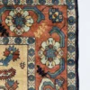 Detailed corner view of a red Persian Shahsavar rug showing the wide geometric border and hand-bound wool fringe.