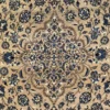 Macro shot of the dense hand-knotted wool pile showing the central floral medallion and intricate vine work in navy and tan.