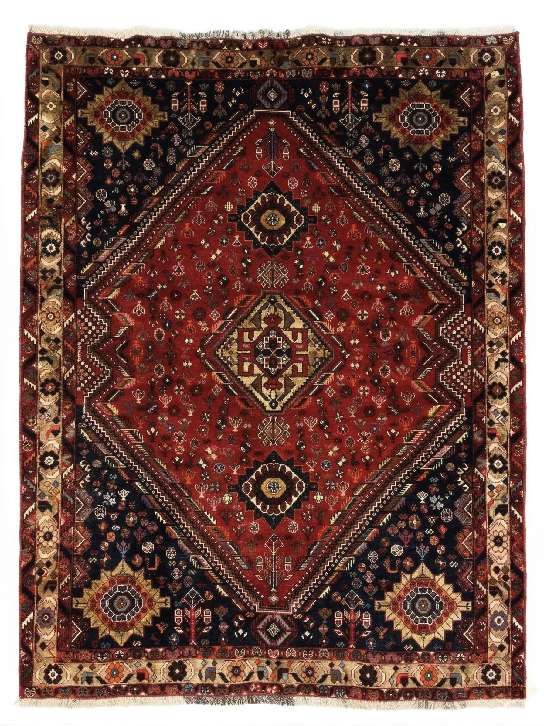 Full overhead view of a rectangular 5' 4" x 7' 3" hand-knotted Persian Qashqai wool rug with a large central diamond medallion on a rich red and navy field.