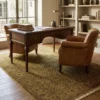 Sophisticated home office with a dark wood desk and leather armchairs, featuring a 6' 1" x 9' olive-gold Indian rug.