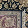 Close-up view of the underside of an Indian wool rug, showing the visible individual hand-tied knots and authentic textile construction.