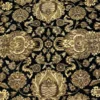 Macro shot of the dense hand-knotted wool pile showing intricate gold floral palmettes on a deep black background.