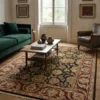 Elegant living room with a green velvet sofa and light wood floors, featuring a 6' x 8' 1" black and burgundy Indian wool rug.