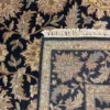 Close-up view of the underside of an Indian wool rug, showing the visible individual hand-tied knots and authentic textile construction.
