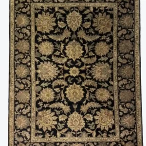 Full overhead view of a 6' x 9' 2" hand-knotted Indian wool rug with a black field and large-scale sage green and gold floral palmettes.