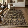 Modern living room with a white armchair and dark wood floors, featuring a 6' x 9' 2" black and sage Indian wool rug.