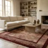 Bright modern living room with a neutral sofa and light wood floors, featuring a 6' 2" x 7' 1" burgundy Afghan Gabbeh rug.