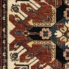Macro shot of the dense hand-knotted wool pile on a Kazak rug showing bold geometric stars and latch-hook motifs in red, blue, and gold.