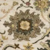 Macro shot of the dense hand-knotted wool pile showing intricate gold and sage green floral motifs on a deep black background.