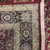 Close-up view of the underside of a red Indian wool rug, showing the visible individual hand-tied knots and authentic textile construction.