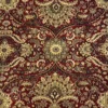 Macro shot of the dense hand-knotted wool pile showing intricate gold and tan floral motifs on a deep ruby red background.