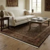 Bright modern living room with a neutral sofa and light wood floors, featuring a 5' x 9' olive-gold Indian wool rug centered under a wooden coffee table.