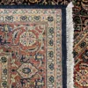 Close-up view of the underside of a tobacco and rust Indian wool rug, showing the visible individual hand-tied knots and authentic textile construction.