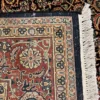 Close-up view of the underside of a square tobacco and rust Indian wool rug, showing individual hand-tied knots and authentic textile construction.
