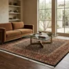 Modern living room with a rust velvet sofa and glass coffee table, featuring a 6x6 square tobacco and rust Indian wool rug.