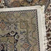 Close-up view of the underside of a square Indian wool rug, showing the visible individual hand-tied knots and authentic textile construction.