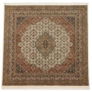 Full overhead view of a 6' 9" x 6' 10" hand-knotted Indian wool rug with a large terracotta and sage medallion on a cream and black field.
