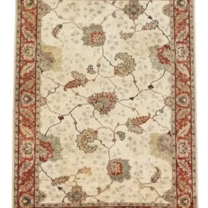 Full overhead view of a rectangular 6' x 8' 11" hand-knotted Indian wool rug with a luminous ivory field and large-scale terracotta and sage floral patterns.