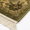 Detailed corner view of a yellow Indian wool rug showing the ornate botanical border and clean white hand-bound fringe.